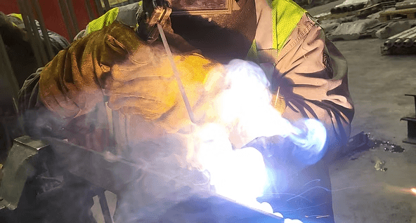 Welder at work with stick welding arc